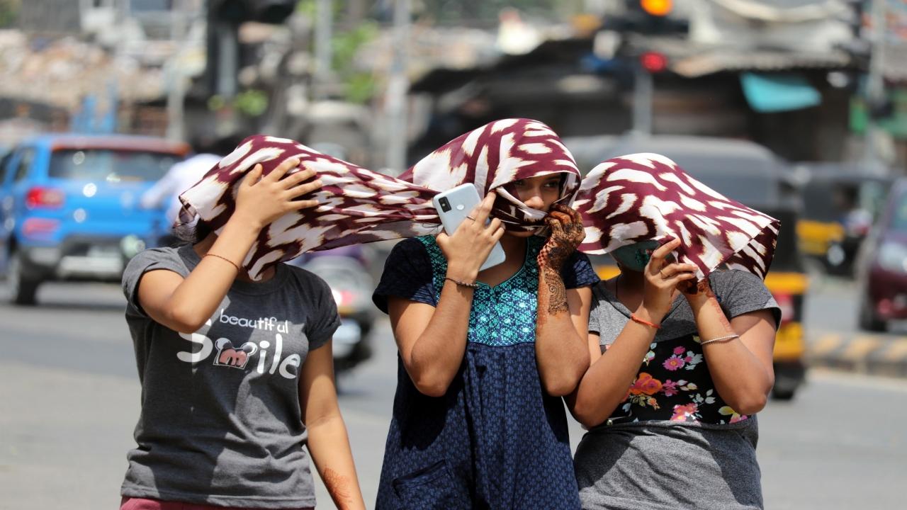 Three friends are seen covering themselves with scarves to beat the heat at Goregaon East. Pic/Anurag Ahire